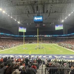 Fans fill the stands inside the Alamodome in San Antonio during a UTSA Roadrunners football game, with the field lit beneath the stadium roof