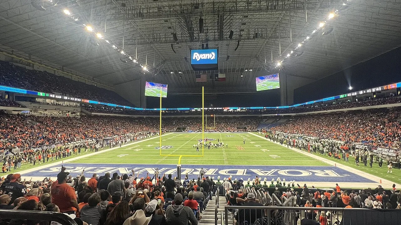 Fans fill the stands inside the Alamodome in San Antonio during a UTSA Roadrunners football game, with the field lit beneath the stadium roof