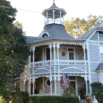 The Bailey House, a blue Victorian home with a corner turret and wraparound porch, in Warren, Arkansas.