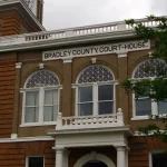The brick Bradley County Courthouse in Warren, Arkansas, with arched windows and a sign reading Bradley County Court-House