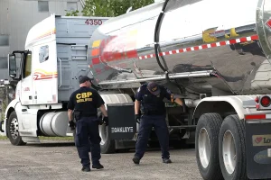 Two U.S. Customs and Border Protection officers inspect a tanker truck at the Port of Detroit, Michigan.