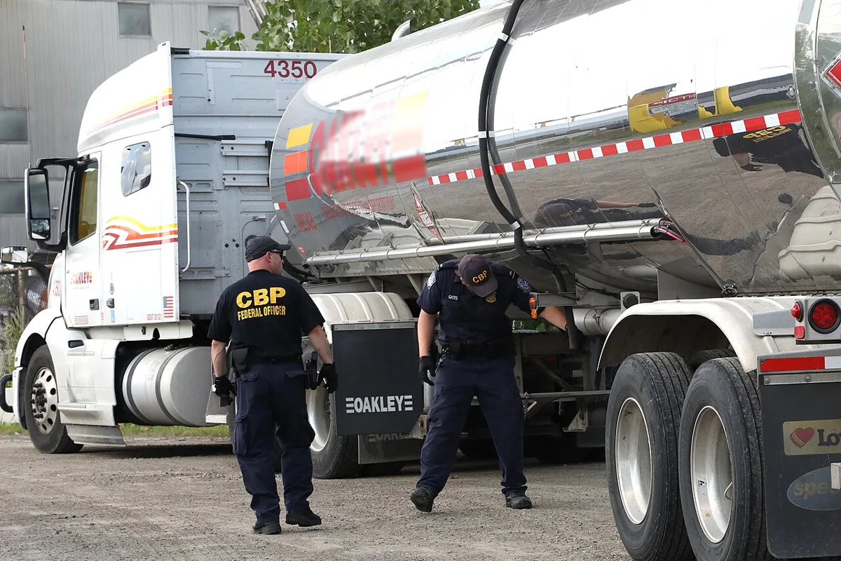 Two U.S. Customs and Border Protection officers inspect a tanker truck at the Port of Detroit, Michigan.