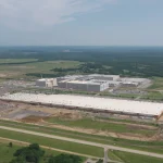 Aerial view of the Google data center campus outside Pryor, Oklahoma, with large white-roofed buildings surrounded by fields and trees.