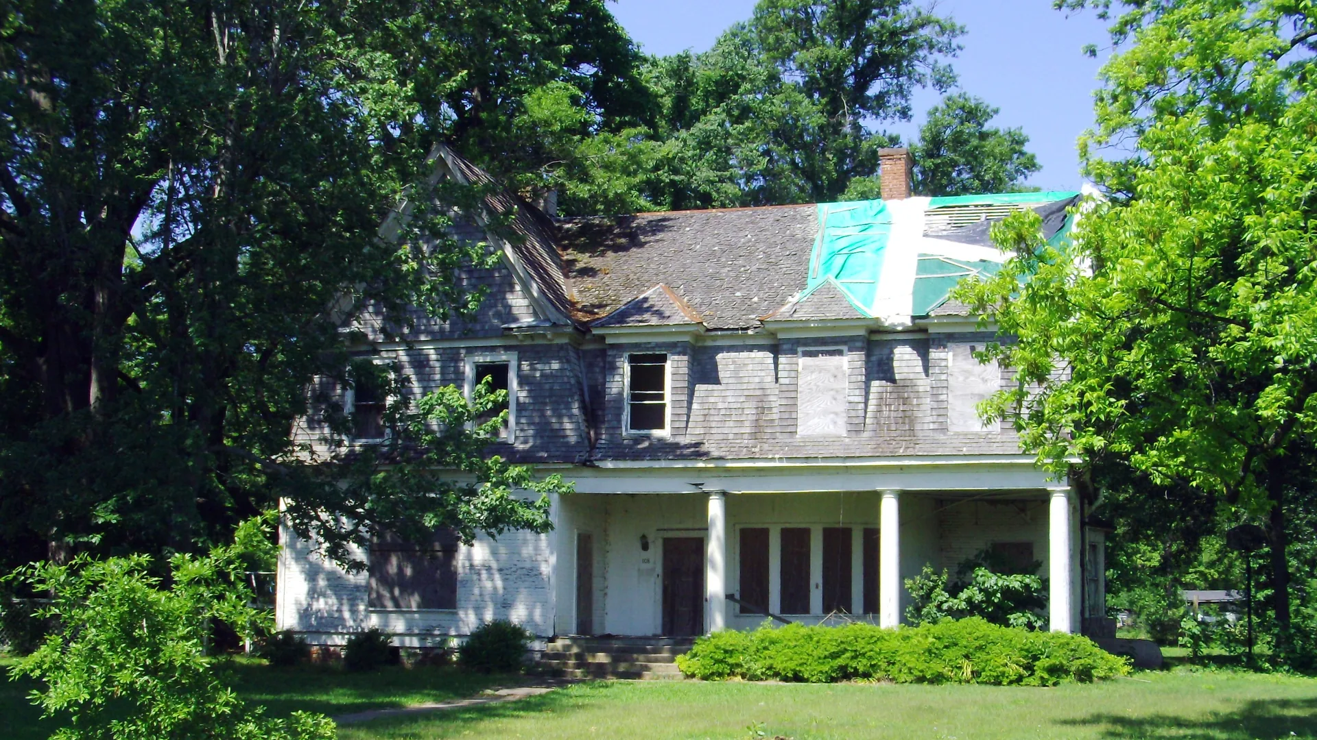 The historic Crenshaw-Burleigh House in Dermott, a two-story house with a columned porch behind a green lawn.
