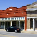 Brick storefronts and a former bank building along Main Street in downtown Dumas.