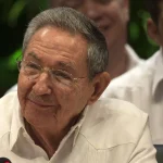 Former Cuban leader Raúl Castro, wearing glasses and a white guayabera shirt, seated at a microphone during a 2016 summit.