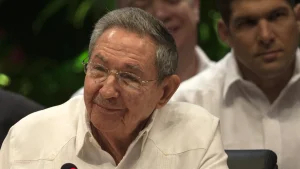 Former Cuban leader Raúl Castro, wearing glasses and a white guayabera shirt, seated at a microphone during a 2016 summit.