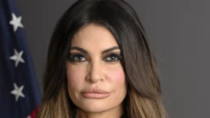 Official portrait of Kimberly Guilfoyle as U.S. ambassador to Greece, with a U.S. flag behind her