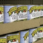 Rows of canned collard greens stacked on food pantry shelves.