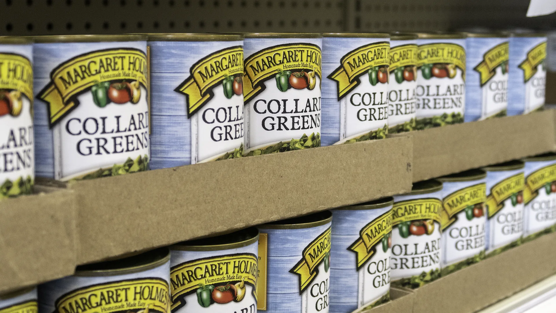 Rows of canned collard greens stacked on food pantry shelves.
