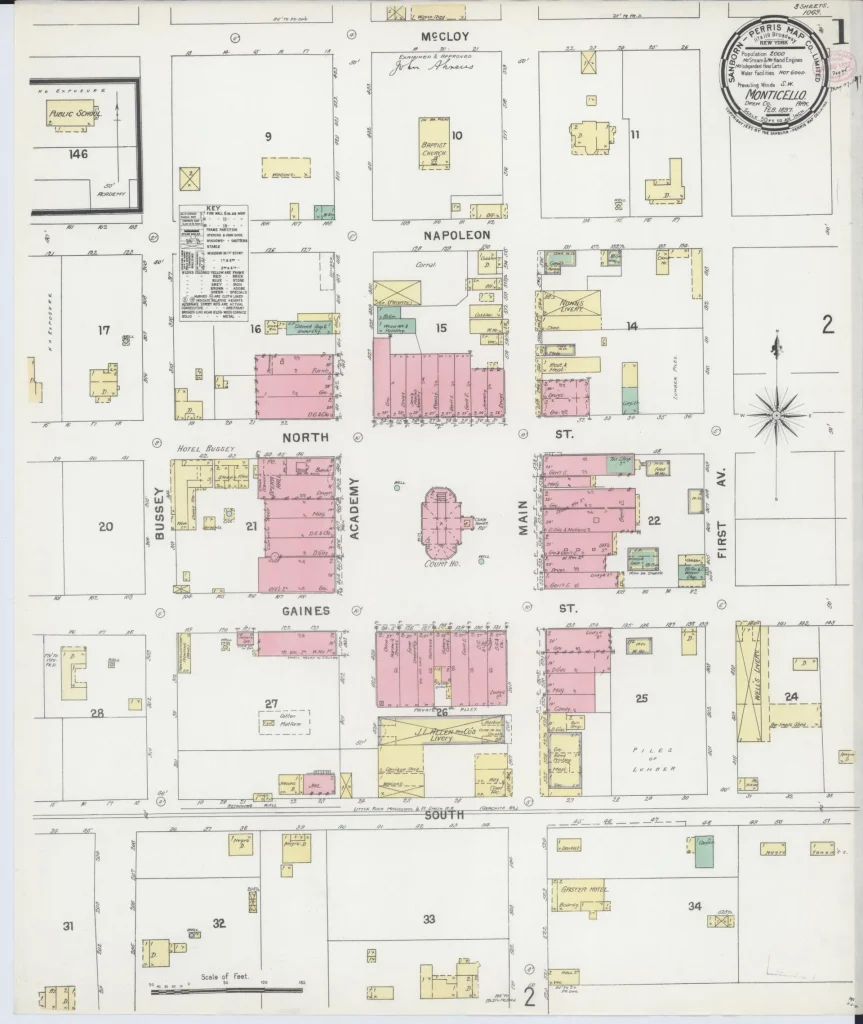 Hand-colored 1897 fire insurance map sheet of downtown Monticello, showing blocks of pink brick and yellow frame buildings along the streets, with a round title seal near the top.