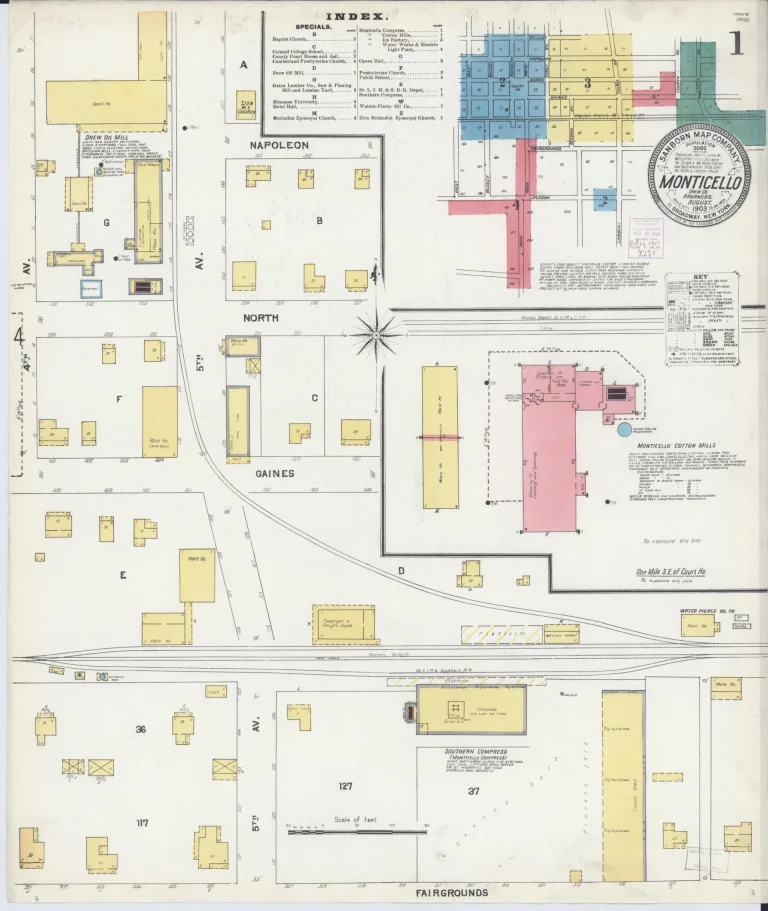 Hand-colored 1903 fire insurance map title sheet for Monticello, with a round title seal, a small color-coded key map of the map sheets covering town, a printed index, and blocks of outlying buildings below.