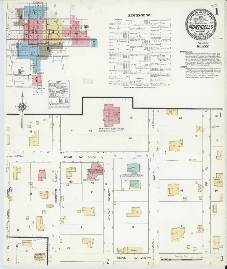 Hand-colored 1912 fire insurance map title sheet for Monticello, with a round title seal, a small color-coded key map of the map sheets covering town, a printed index, and blocks of outlying buildings below.