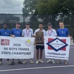 Monticello High School boys tennis players hold a 2026 4A Boys Tennis State Champions banner and a state trophy on a tennis court.