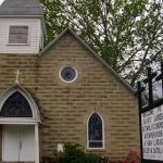 St. Luke's Catholic Church, a stone church with a white steeple, in Warren, Arkansas.