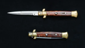 An Italian-style stiletto switchblade knife shown open and closed on a black background.