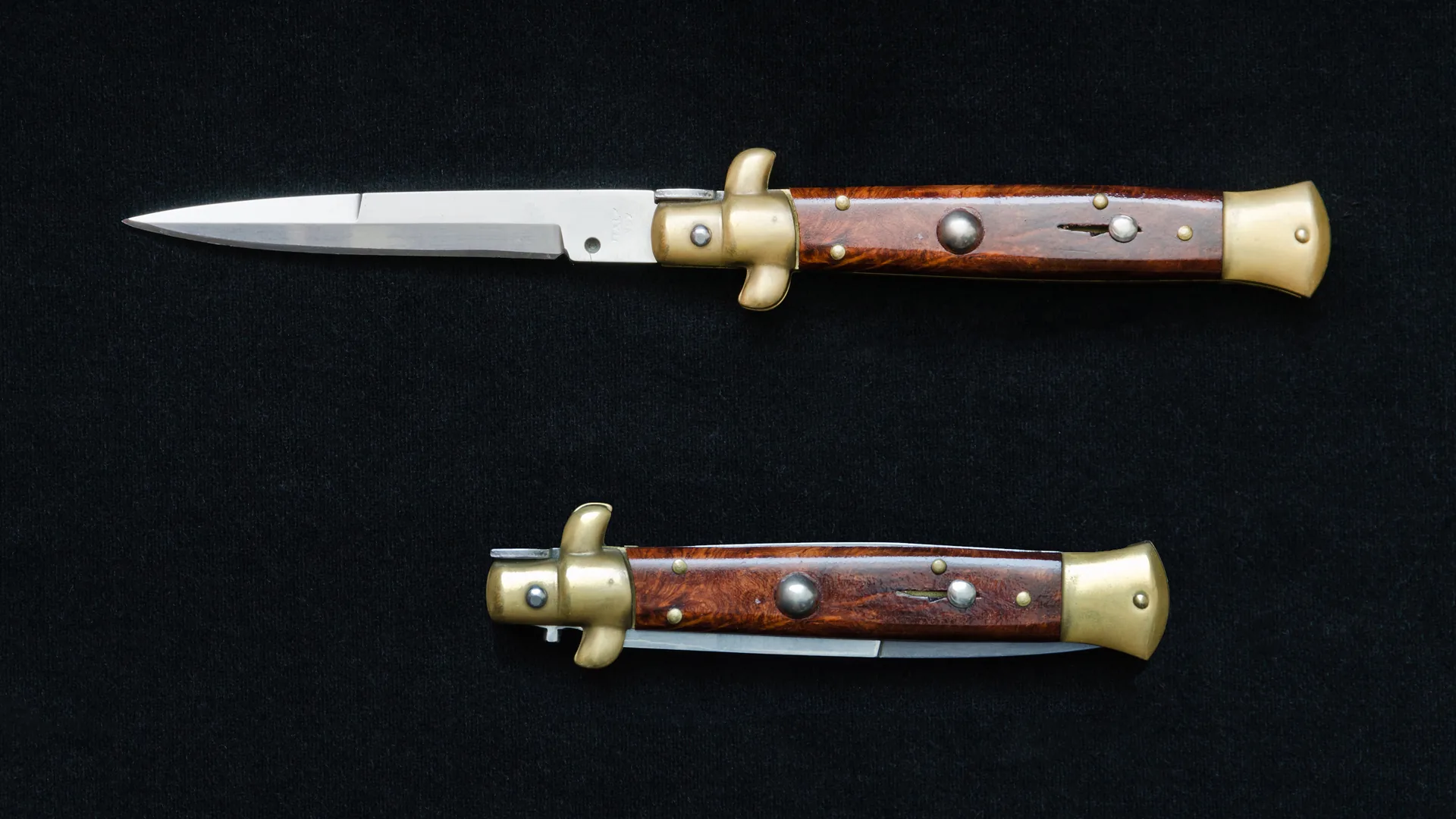 An Italian-style stiletto switchblade knife shown open and closed on a black background.