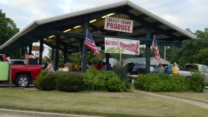 Tables of local produce under a Local Grown Produce Market banner in Texarkana, Arkansas.