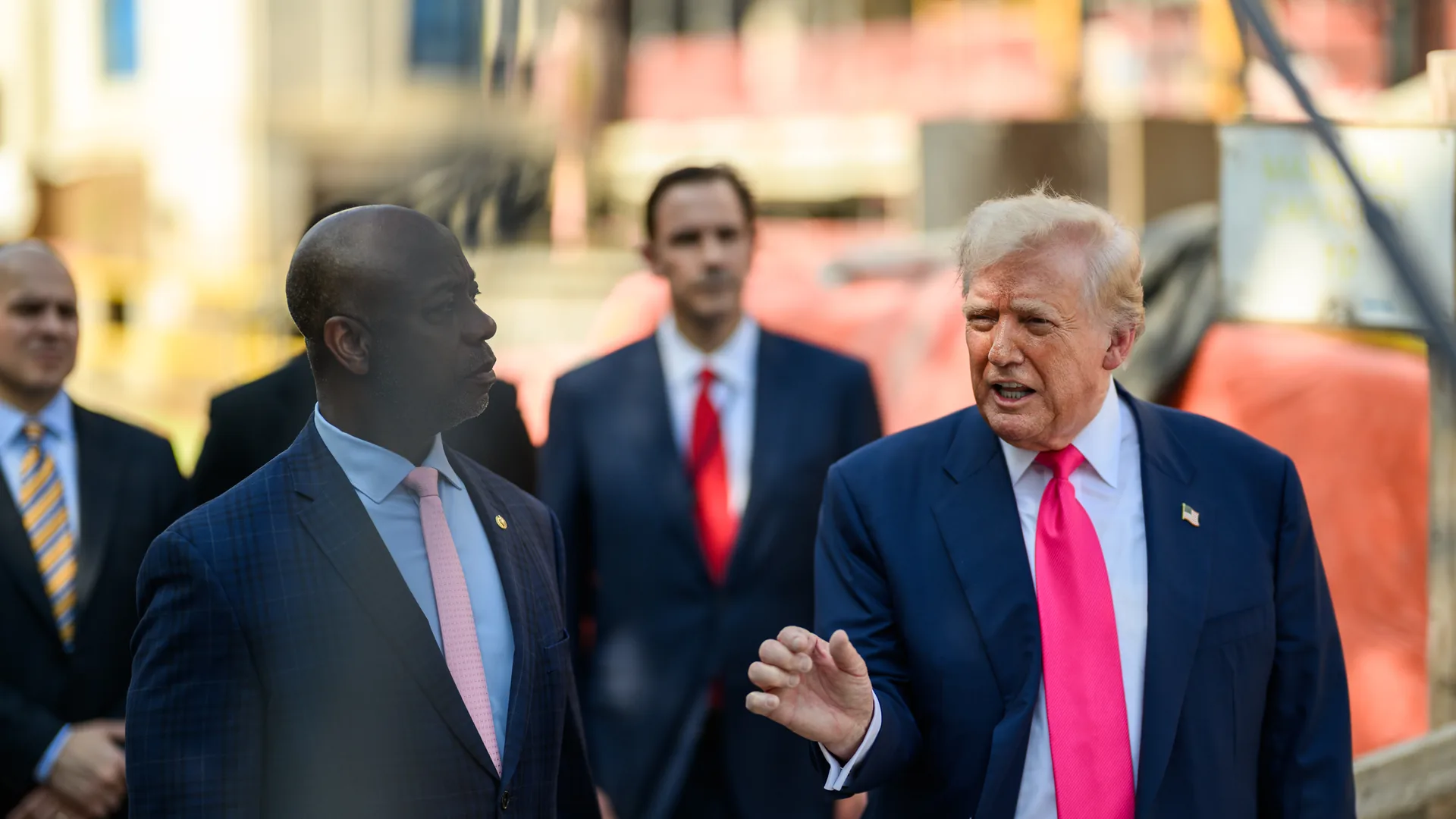 President Donald Trump speaks to reporters beside Sen. Tim Scott outside the Federal Reserve in Washington in July 2025.