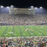 Players line up under the lights at FirstBank Stadium in Nashville during a 2023 Vanderbilt home game.