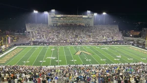 Players line up under the lights at FirstBank Stadium in Nashville during a 2023 Vanderbilt home game.