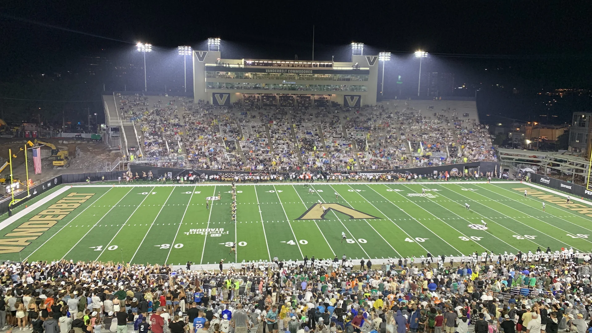 Players line up under the lights at FirstBank Stadium in Nashville during a 2023 Vanderbilt home game.