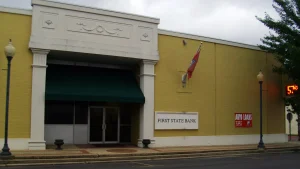 Storefronts along a brick street in downtown Warren, Arkansas, under a cloudy sky