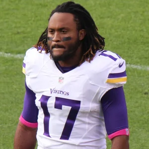 Jarius Wright holding a football helmet at a stadium in 2015.