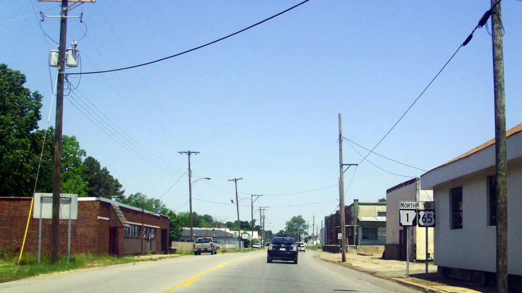 Highway 1 running through downtown McGehee, Arkansas, with single-story brick and wood commercial buildings along the street.