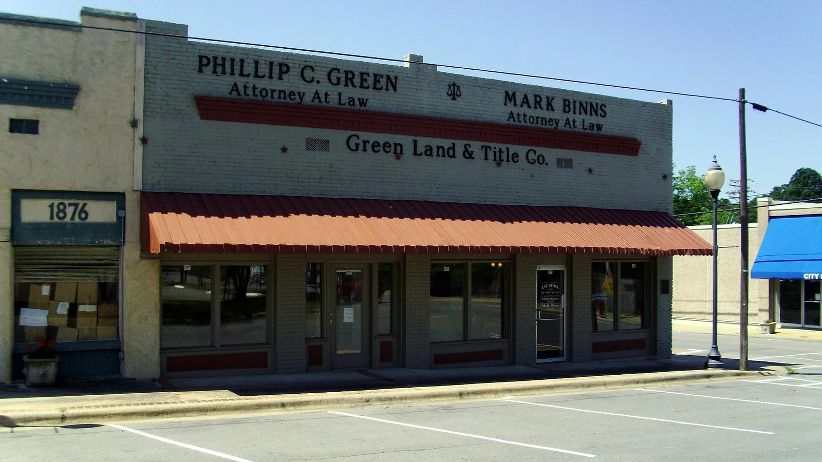 A one-story commercial building in downtown Star City, Arkansas, with signs for law and title offices.