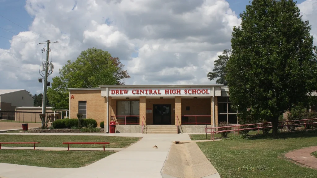 Drew Central High School in Monticello, Arkansas, a one-story school building with a sign over the main entrance and a wide lawn in front.
