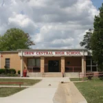 Drew Central High School in Monticello, Arkansas, a one-story school building with a sign over the main entrance and a wide lawn in front.