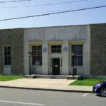 The Monticello, Arkansas, post office, a one-story building with a light stone front and large windows.