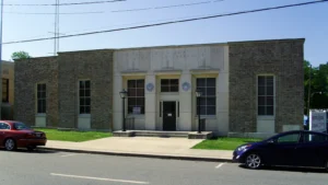 The Monticello, Arkansas, post office, a one-story building with a light stone front and large windows.
