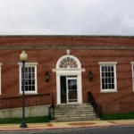 The Warren, Arkansas, post office, a symmetrical red-brick building with white trim, a central portico and front steps.
