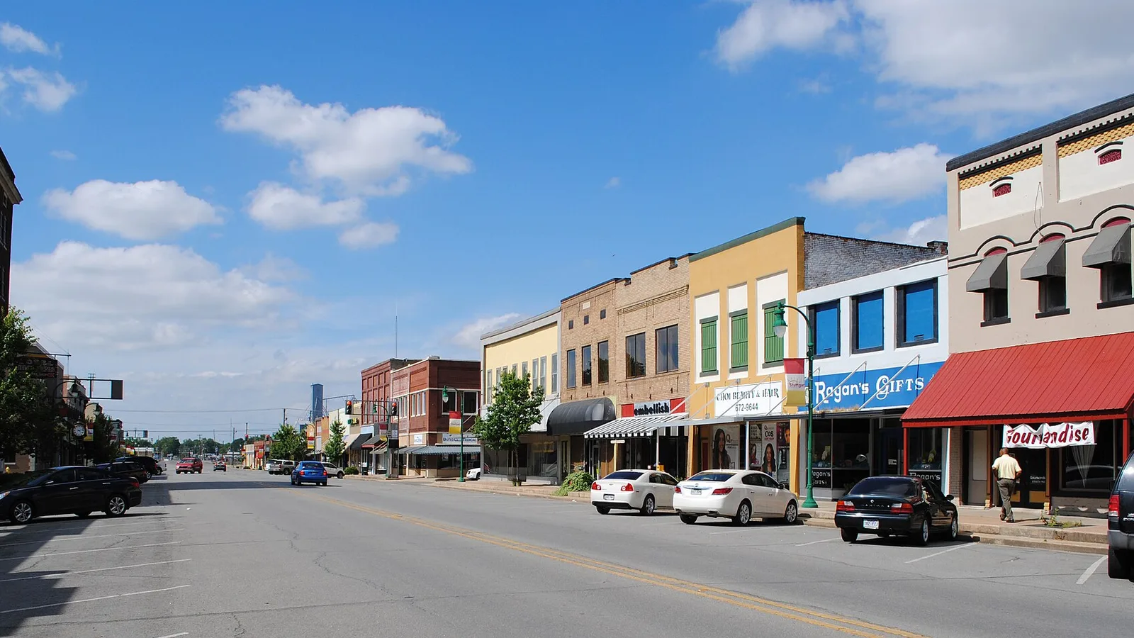 Two-story storefronts in white, red and yellow along a downtown street in Stuttgart, Arkansas.