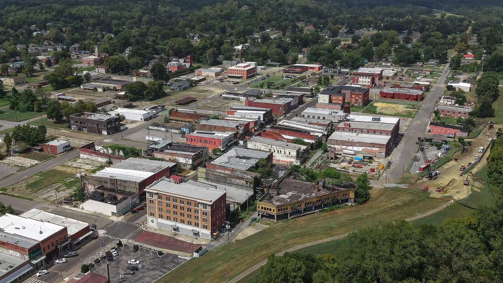 Aerial view of downtown Helena, Arkansas, on the bank of the Mississippi River with green hills behind.