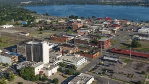 Aerial view of downtown Pine Bluff, Arkansas, with commercial buildings and the Arkansas River in the distance.