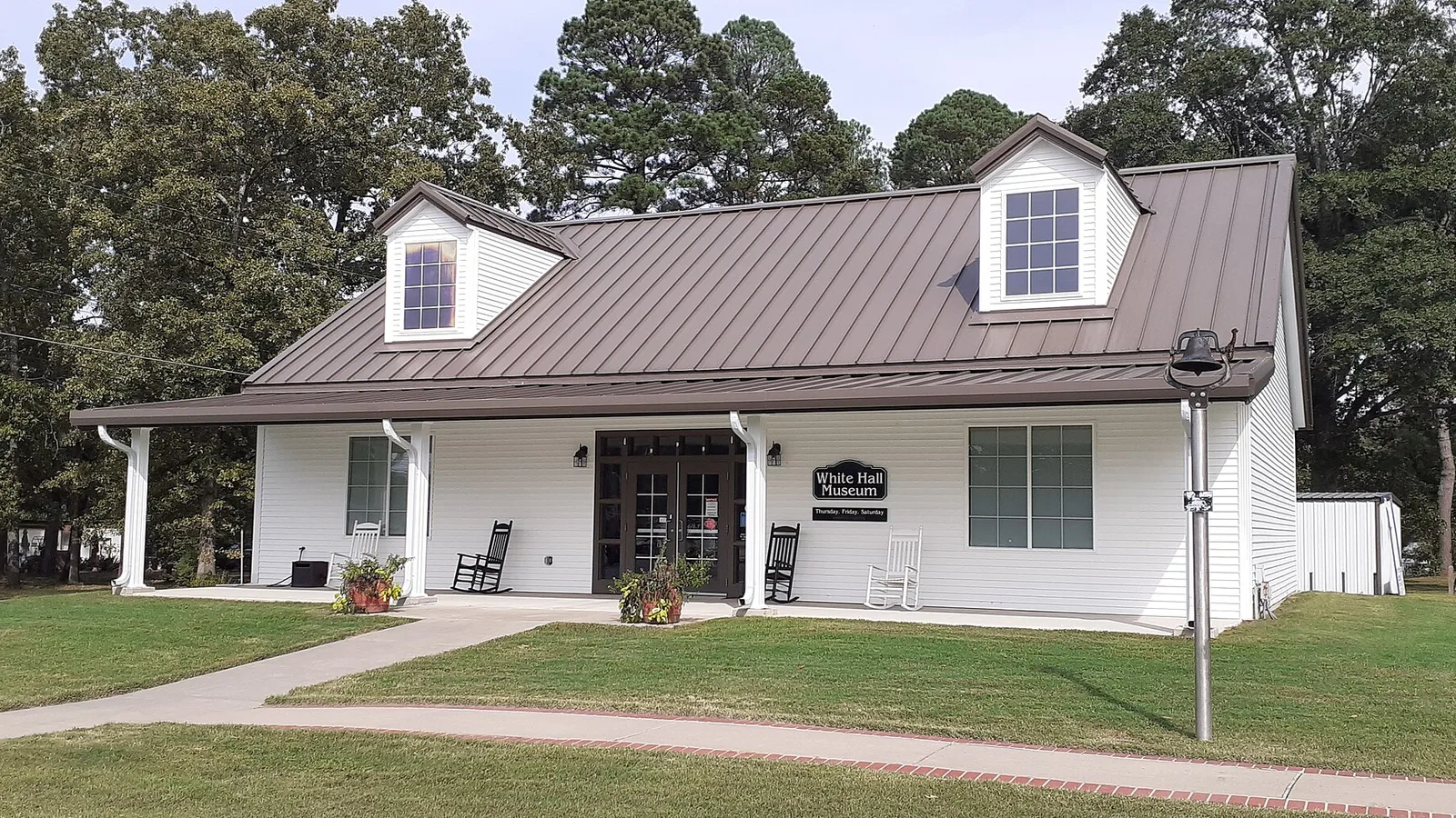 The White Hall city museum on Dollarway Road, a small white building with a brown metal roof.