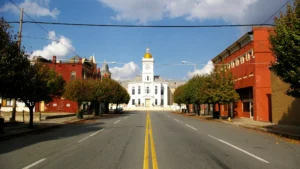 A straight street in downtown Pine Bluff, Arkansas, leading toward the white courthouse with its gold dome, with brick buildings on both sides.
