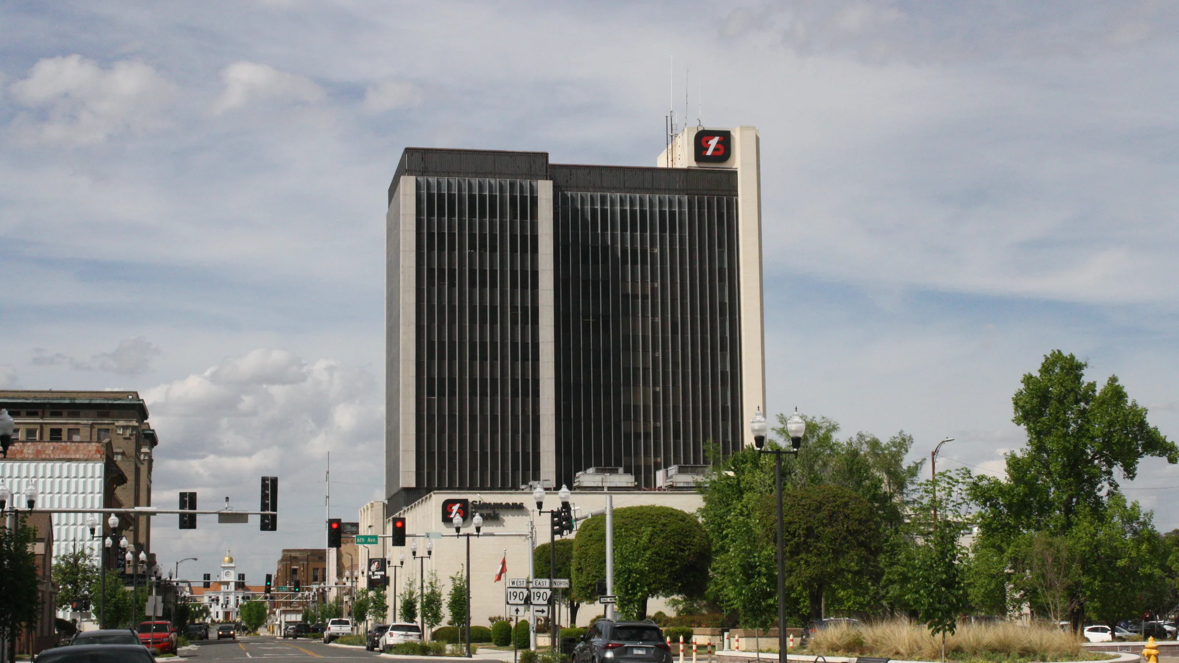 The Simmons Bank tower in downtown Pine Bluff, Arkansas, a tall dark glass building rising above lower downtown buildings.
