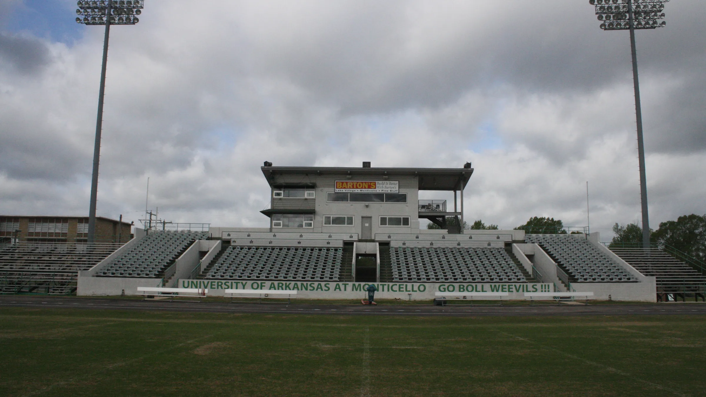 The grandstand and press box at Cotton Boll Stadium at the University of Arkansas at Monticello, with a sign reading Go Boll Weevils.